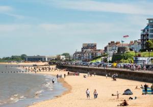 a group of people on a beach near the water at Spacious Seaside House in Cleethorpes