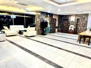 un vestíbulo con sofás, TV y mesa en incheon Airport Hotel June, en Incheon