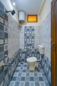 La salle de bains est pourvue de toilettes et de carrelage bleu et blanc. dans l'établissement Le Mission Stay, à Pondichéry