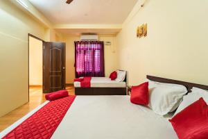 - une chambre avec 2 lits et des oreillers rouges dans l'établissement Le Mission Stay, à Pondichéry