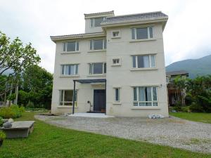 un grande edificio bianco con una porta in un cortile di Village Tree B&B a Ji'an