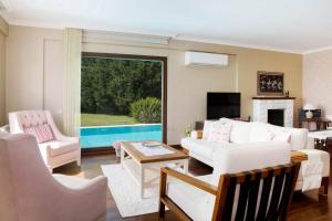 uma sala de estar com mobiliário branco e uma piscina em Villa Rana by Important Group Travel em Yalıkavak