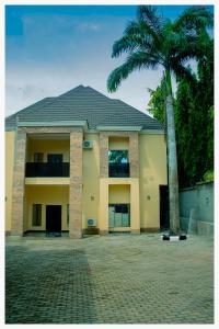 a building with a palm tree in front of it at House 7A in Enugu