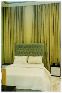 uma cama com uma cabeceira verde num quarto em House 7A em Enugu