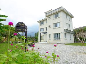 un edificio con un orologio e dei fiori davanti di Village Tree B&B a Ji'an