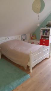 1 dormitorio con cama blanca y alfombra verde en Adossée à la colline, en Willer-sur-Thur