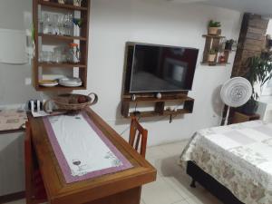 un soggiorno con TV e tavolo di Loft conceito aberto - 4 pessoas a Araranguá