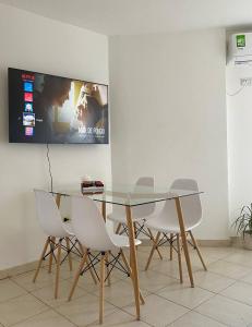 comedor con mesa de cristal y sillas blancas en Espejito espejito en Córdoba