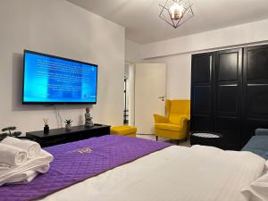 a bedroom with a bed and a tv on the wall at Coresi Mall Area Studios & Apartments by GLAM in Braşov