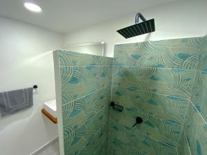 y baño con ducha de color verde y azul. en Casa EstadioMed en Medellín