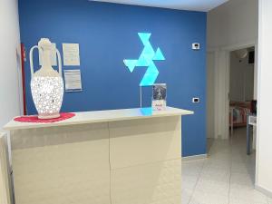 een blauwe muur met een vaas op een toonbank bij Hibiscus in Taranto