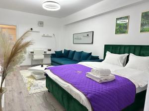 a bedroom with a bed and a blue couch at Coresi Mall Area Studios & Apartments by GLAM in Braşov