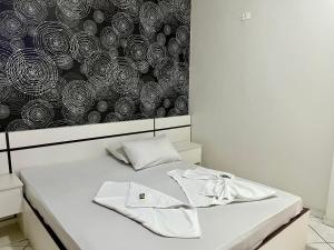 a bed with two white towels on top of it at Hotel Sunshine in São Bernardo do Campo