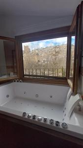 una gran bañera blanca en una habitación con ventana en Casas Alcala, en Alcalá del Júcar