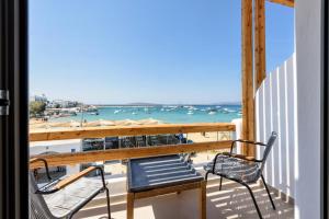 a balcony with two chairs and a view of the ocean at KIANO SUITES in Kampos Paros
