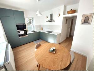 a living room with a wooden table and a kitchen at Comfort apartment in Warsaw +8 photos