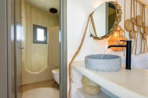 a bathroom with a sink and a mirror on a counter at KIANO SUITES in Aliki