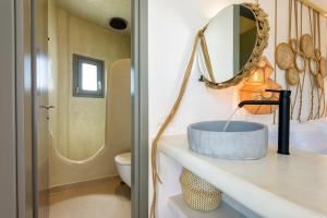 a bathroom with a sink and a mirror on a counter at KIANO SUITES in Kampos Paros