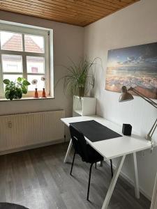 een kamer met een wit bureau en een tafel met een lamp bij Wohnung in Bad Münder am Deister in Bad Münder am Deister