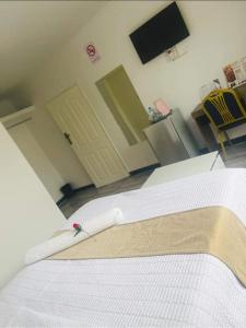 a bedroom with a bed with a white bedspread on it at Andromeda Executive Lodge in Ndola