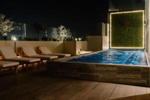 una piscina por la noche con sillas y mesas en Exclusivo, lujoso y nuevo apartamento en zona 10, en Guatemala