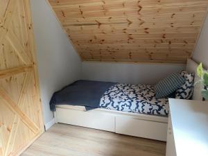 RzeczkaにあるDOMKI NA SKARPIEの木製の天井の客室のベッド1台分です。