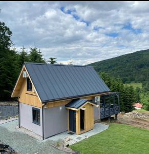 a small house with a metal roof at DOMKI NA SKARPIE in Rzeczka