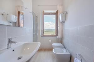 a white bathroom with a sink and a toilet at Antica Grancia Di Quercecchio in Montalcino