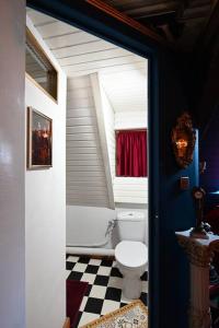 a bathroom with a toilet and a checkered floor at Charme baroque/Séjour romantique in Mons