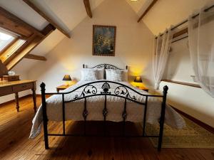 a bedroom with a black bed in a attic at Walnut Tree Gite Brittany in Boderel