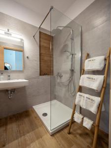 a bathroom with a shower and a sink and a glass shower stall at Trikala Leisure in Tríkala