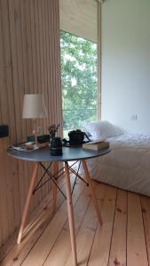 uma mesa com um candeeiro e uma cama num quarto em Nature Rooms-Cozy Cabin in the Woods 