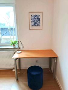 a desk with a blue chair next to a window at Comfort apartment in Warsaw