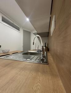uma cozinha com lavatório e piso em madeira em Apartma Tisa Bohinj em Bohinj