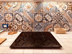 a room with a tile wall with a large rug at Villa sul Mare Calalunga Calasetta Sant Antioco in Calasetta