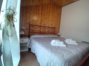 1 dormitorio con 1 cama con toallas en Residence Giardino, en Montecreto