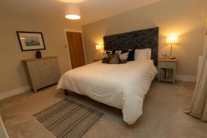 ein Schlafzimmer mit einem großen weißen Bett mit Kissen in der Unterkunft Oulton House - Beautiful Restored 2 Bedroom Property in Spofforth in Spofforth