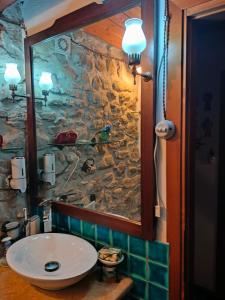 a bathroom with a sink and a stone wall at Casa di Pietra in Usellus