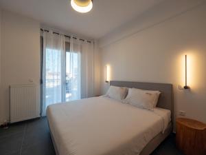 a bedroom with a white bed and a large window at Trikala Leisure in Tríkala