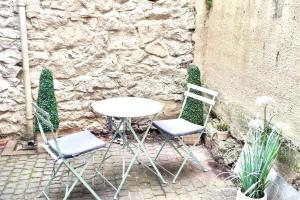 two chairs and a table in front of a stone wall at Stylishly refurbished townhouse in Bristol