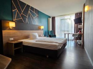 Hotel Luise Mannheim - by SuperFly Hotels في مانهايم: غرفة الفندق بسرير وطاولة