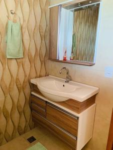 a bathroom with a sink and a mirror at Recanto NS Aparecida in Socorro