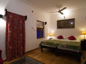 a bedroom with a bed and a ceiling fan at Yogis Guest House in Jodhpur