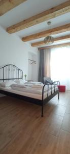 a large bed in a room with a wooden floor at Historic Center Studio in Braşov