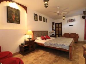 a bedroom with a bed with red pillows on it at Yogis Guest House in Jodhpur