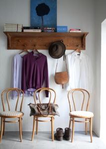a room with two chairs and a shelf with clothes at Alapiha Apartments in Tammisaari
