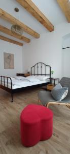 a room with two beds and a red ottoman at Historic Center Studio in Braşov