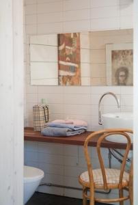 a bathroom with a sink and a toilet and a chair at Alapiha Apartments in Ekenäs