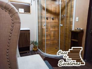 La salle de bains est pourvue d'une douche et d'une chaise. dans l'établissement Casa de las Escaleras, à Pátzcuaro