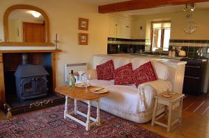 a living room with a white couch and a stove at Tre-Allt Gorgeous Cottage in Dolgellau